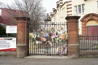 Detail of main gates with memorial flowers dedicated to a fallen soldier and former pupil.