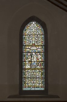 North aisle. View of stained glass window on west wall.