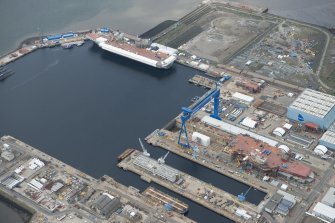 Oblique aerial view of Rosyth Naval Dockyard showing the construction of two aircraft carriers, looking W.