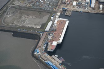 Oblique aerial view of the Main Basin, Rosyth Naval Dockyard showing the construction of an aircraft carrier, looking N.
