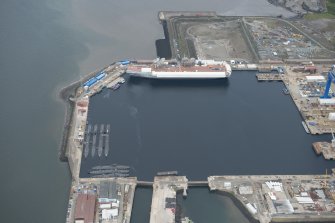 Oblique aerial view of the Main Basin, Rosyth Naval Dockyard showing the construction of an aircraft carrier, looking W.
