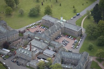 Oblique aerial view of Merchiston Castle School, including the main building and memorial hall and Fives Courts, looking SE.