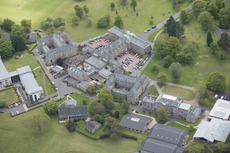 Oblique aerial view of Merchiston Castle School, including the main building and memorial hall, Chalmers Boarding House, Rogerson Boarding House and Colinton House, looking ESE.
