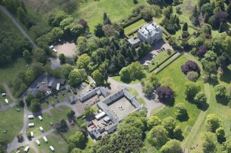Oblique aerial view of Mortonhall House, terraced garden, stable court and granary, looking S.
