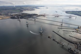 Oblique aerial view of the construction of the Queensferry Crossing with the Forth Road Bridge and the Forth Bridge beyond, looking E.