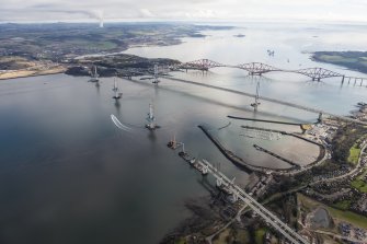 Oblique aerial view of the construction of the Queensferry Crossing with the Forth Road Bridge and the Forth Bridge beyond, looking ENE.
