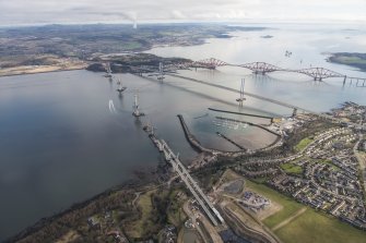 Oblique aerial view of the construction of the Queensferry Crossing with the Forth Road Bridge and the Forth Bridge beyond, looking NE.