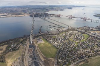 Oblique aerial view of the construction of the Queensferry Crossing, the Forth Road Bridge and the Forth Bridge, looking NNE.