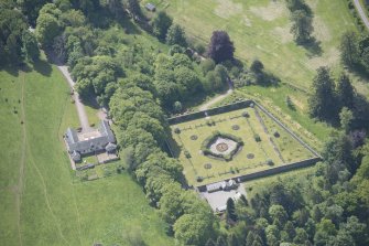 Oblique aerial view of Ballindalloch Castle walled garden and stables, looking S.