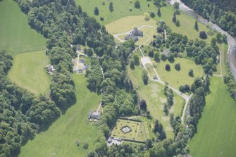 Oblique aerial view of Ballindalloch Castle, walled garden and stables, looking S.