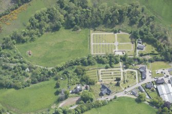Oblique aerial view of Mortlach Parish Church, burial gounds and watch house, looking E.