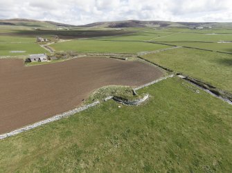 Oblique aerial view of the broch near Manse of Harray, looking SE.