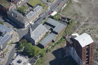 Oblique aerial view of Dumbarton Distillary and Riverside Parish Church, looking NE.