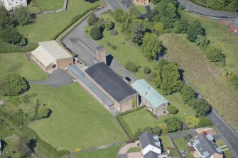 Oblique aerial view of the Holy Family Roman Catholic Church, looking NW.