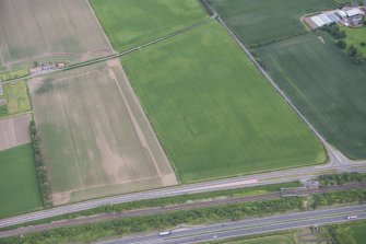 Oblique aerial view of the cropmarks of the settlement at Knowes, looking N.