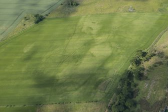 Oblique aerial view of the cropmarks of the enclosure and the pit-defined boundary system, looking WSW.