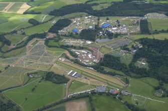 Oblique aerial view of the setting up of T in the Park at Strathallan centred on the airfield, looking SE.