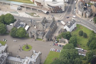 Oblique aerial view of the Memorial to King Edward VII, Thomson's Court, Holyrood Palace Gatehouse, Holyrood free Church and School, Abbey Sanctuary and Holyrood Palace Yard Fountain,  looking SW.