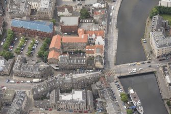 Oblique aerial view of 59-63 Bernard Street, the National Commercial Bank of Scotland, 24-25 Maritime Street, 27-31 Bernard Street, 36-37 Shore, Carpet Lane Flour Mill and Lamb's House, looking SSW.