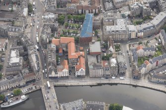 Oblique aerial view of 59-63 Bernard Street, the National Commercial Bank of Scotland, 24-25 Maritime Street, 27-31 Bernard Street, 36-37 Shore, Carpet Lane Flour Mill and Lamb's House, looking ESE.