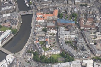 Oblique aerial view of 59-63 Bernard Street, the National Commercial Bank of Scotland, 24-25 Maritime Street, 27-31 Bernard Street, 36-37 Shore, Carpet Lane Flour Mill and Lamb's House, looking NNE.