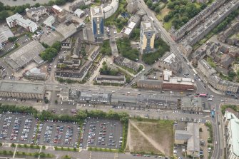 Oblique aerial view of 144-146 Commercial Street Bonded Warehouses, former Leith Nautical College, A&R Tod Flour Mill, 1-7 North Junction Street, 148 Commercial Street Warehouse and 142 Commercial Street Cooperage, looking SSW.
