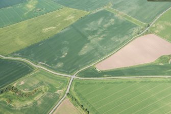 Oblique aerial view of the cropmarks of the settlement at Standingstone, looking NNE.