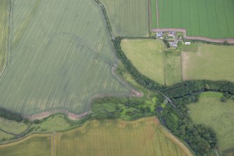 Oblique aerial view of the cropmarks of the fort with Reedy Loch farmstead beyond, looking N.