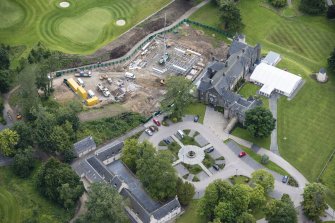 Oblique aerial view of Meldrum House, stables and dovecot, looking ENE.