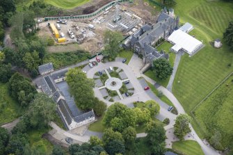 Oblique aerial view of Meldrum House, stables and dovecot, looking NE.