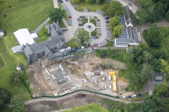 Oblique aerial view of Meldrum House, North Garden House,stables and dovecot, looking SW.