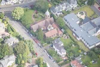 Oblique aerial view of St Cuthbert's Episcopal Church and 1-7 Colinton Rustic Cottages, looking N.