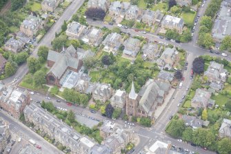 Oblique aerial view of St Matthew's Parish Church and Morningside South United Free Church, looking E.