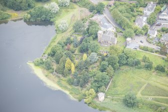 Oblique aerial view of Duddingston Parish Church, Churchyard, Watch Tower and Curling House, looking NW.