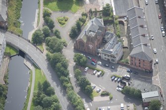 Oblique aerial view of Ruchill Parish Church, Ruchill Parish Church Hall, Janitor's House and Ruchill Bridge, looking SW.