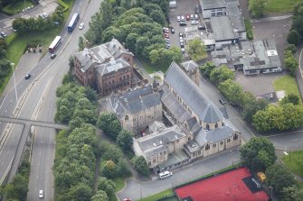 Oblique aerial view of St Mungo's Roman Catholic Church and Martyrs' Public School, looking SSE.