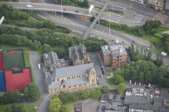Oblique aerial view of St Mungo's Roman Catholic Church and Martyrs' Public School, looking E.