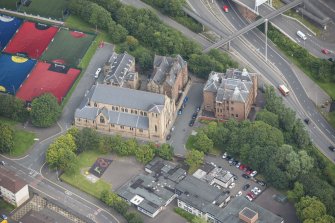 Oblique aerial view of St Mungo's Roman Catholic Church and Martyrs' Public School, looking ENE.