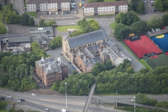 Oblique aerial view of St Mungo's Roman Catholic Church and Martyrs' Public School, looking W.