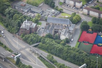 Oblique aerial view of St Mungo's Roman Catholic Church and Martyrs' Public School, looking SW.