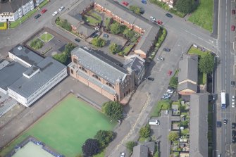Oblique aerial view of Sacred Heart Church and Presbytery, looking N.