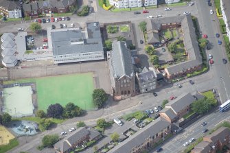 Oblique aerial view of Sacred Heart Church and Presbytery, looking W.