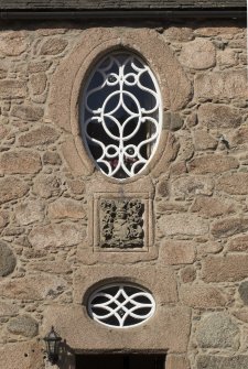 Detail of windows and coat of arms above main entrance.
