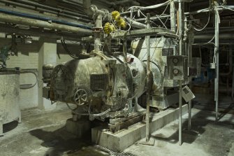 Interior. A5 paper machine house. A5 machine. Basement. Pre-machine refiner. This refines further the pre-refined and blended stock prior to sending onto the Headbox, Cleaner, Attenuator, Flow Box and paper machine Wire
