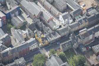 Oblique aerial view of the Canongate, Canongate Tolbooth and Huntly House, looking SSW.
