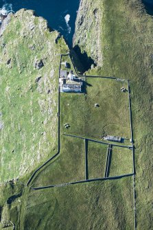 Oblique aerial view of Barra Head Lighthouse, the field boundaries and the possible dun, looking W.
