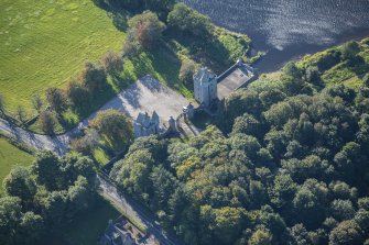 Oblique aerial view of Dunecht House Tower lodges, gates and boathouse, looking SSE.