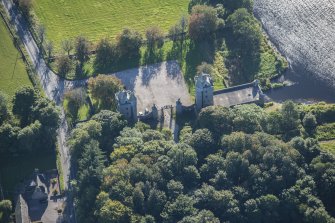 Oblique aerial view of Dunecht House Tower lodges, gates and boathouse, looking ESE.