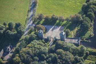 Oblique aerial view of Dunecht House Tower lodges, gates and boathouse, looking E.