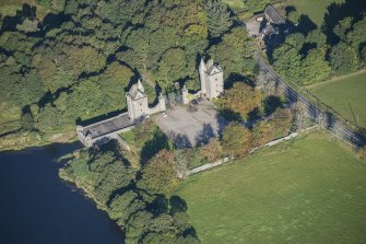 Oblique aerial view of Dunecht House Tower lodges, gates and boathouse, looking NW.